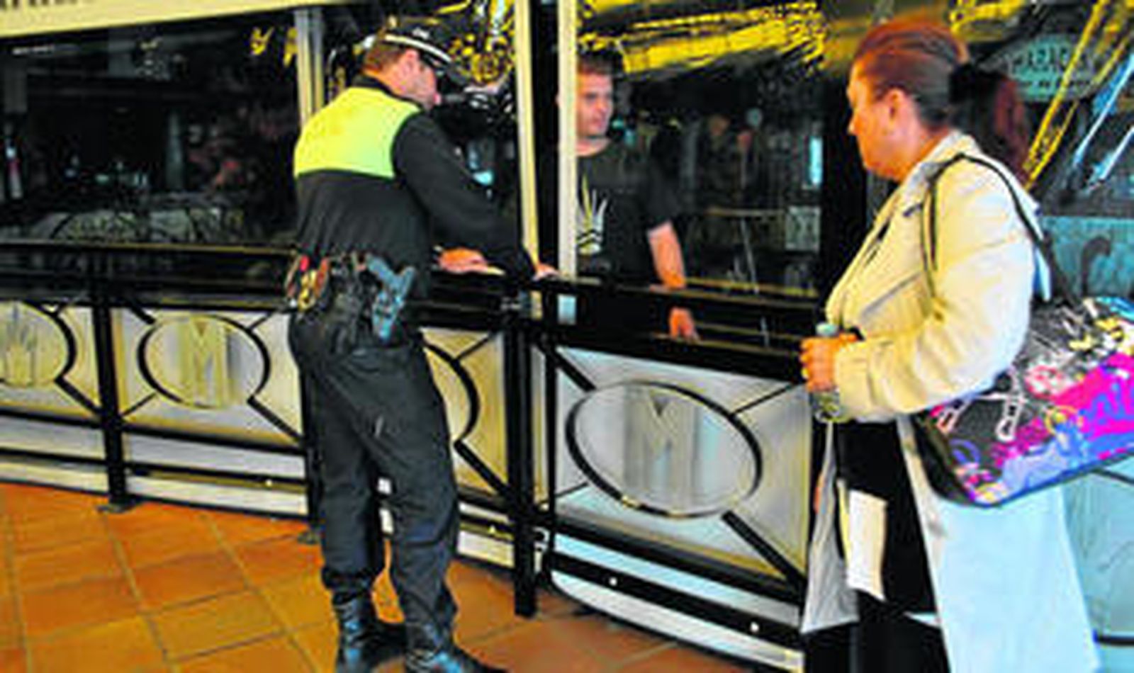 Un policía local coloca el precinto en la terraza de un establecimiento de Puerto Marina.