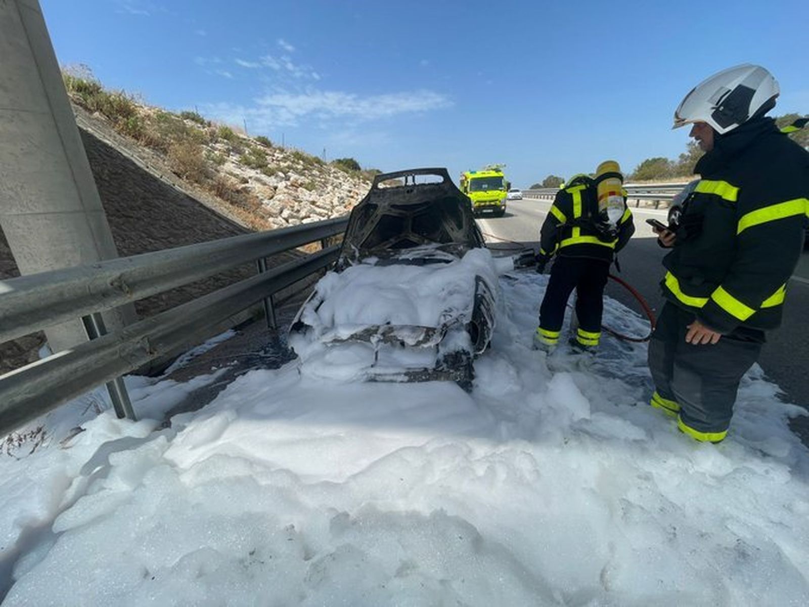 Los bomberos trabajan en la extinción del incendio de un vehículo en Vejer.