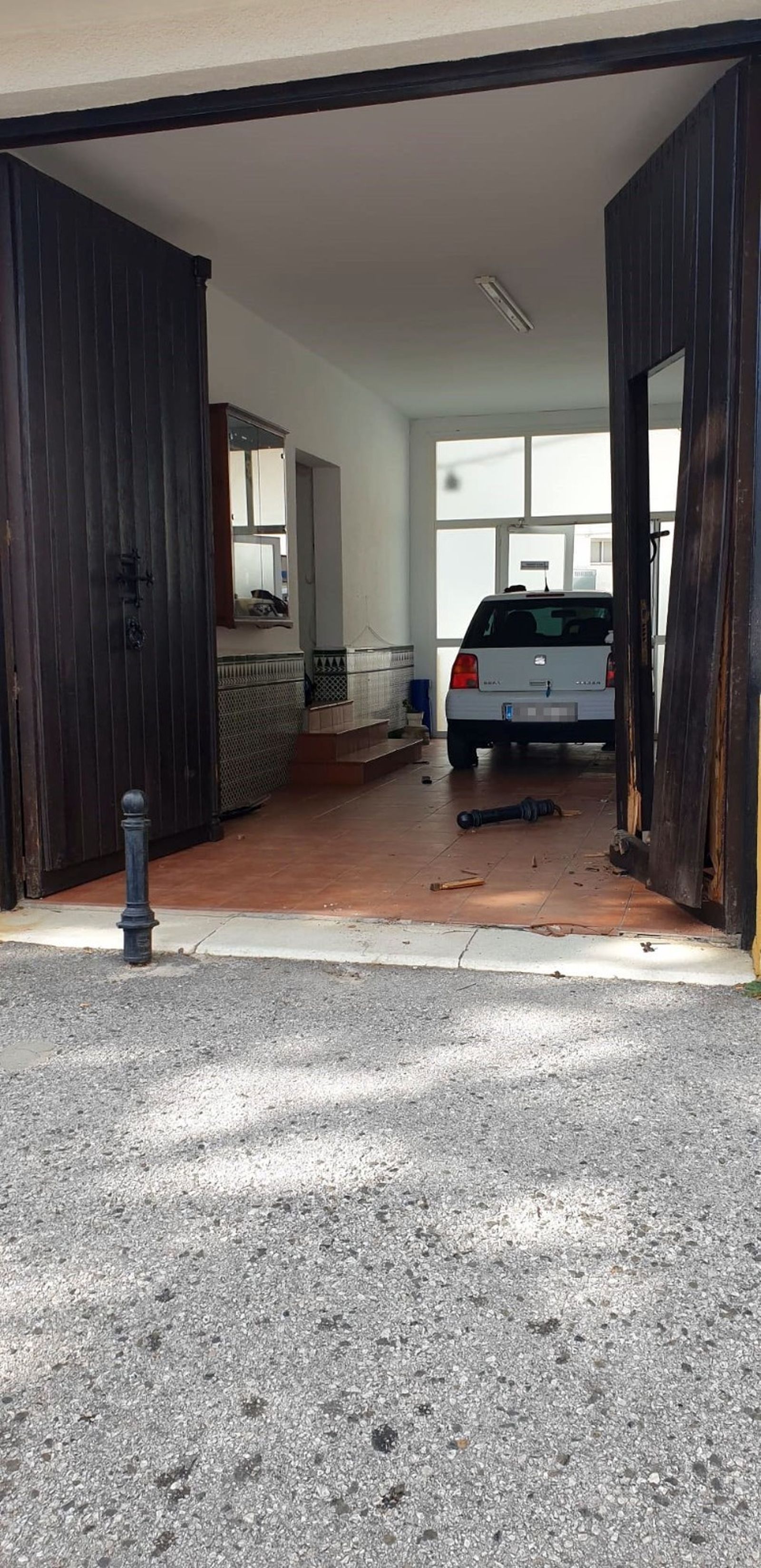 El vehículo ha chocado contra el portón de acceso al edificio.