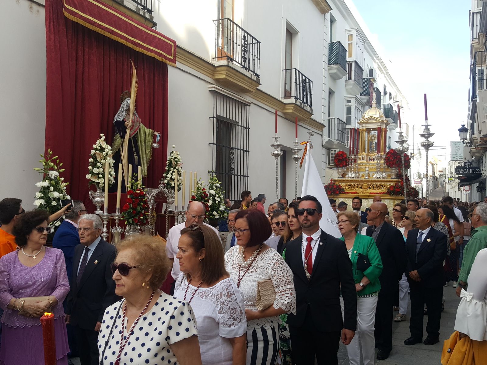 El paso de la custodia se dispone a procesionar ante uno de los altares elaborados por las hermandades en el centro.