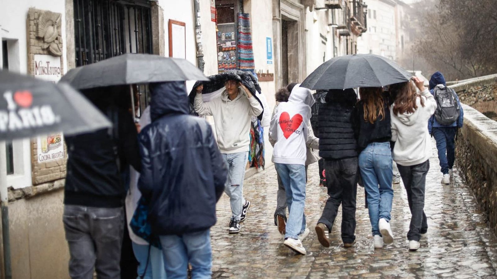 Personas caminan bajo la lluvia durante el temporal en Granada