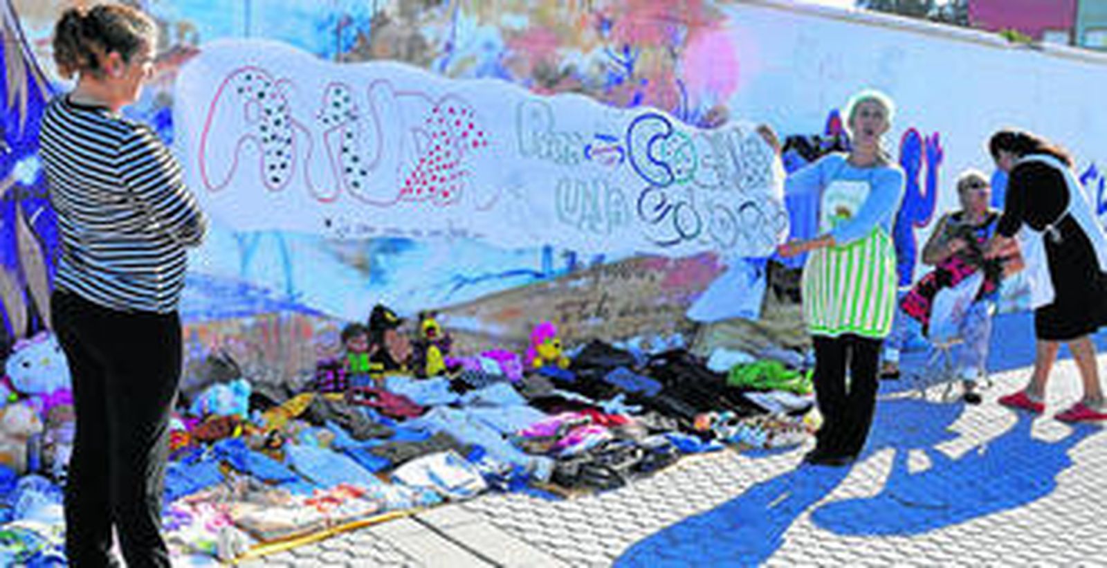 1. Las mujeres de la asociación montan un mercadillo de prendas de segunda mano con el fin de conseguir dinero para comprar alimentos. 2 y 3. Varias participantes en la cocina del centro cívico El Esqueleto, del Polígono Sur.