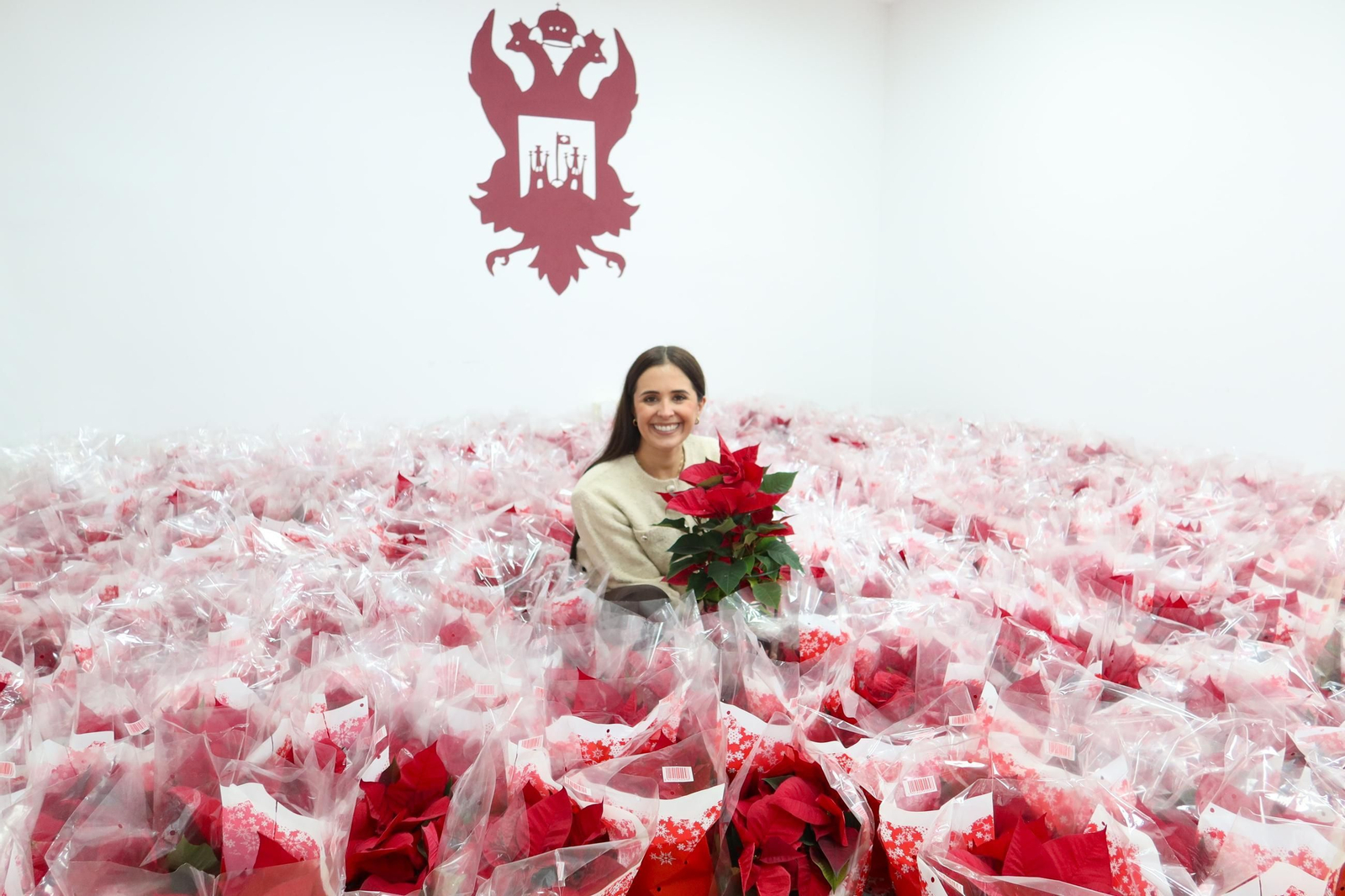 La concejal de comercio, Antonia Marín rodeada de la flor típica de la Navidad.
