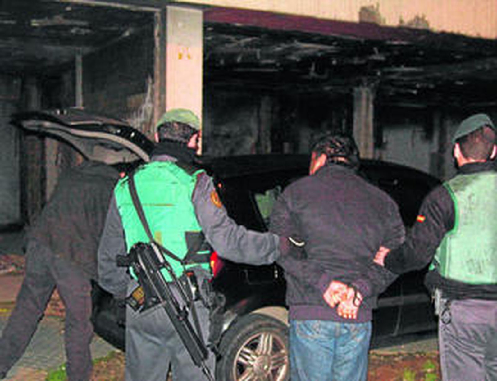 Dos agentes, llevando esposado a uno de los detenidos en las Tres Mil Viviendas, la madrugada de ayer.