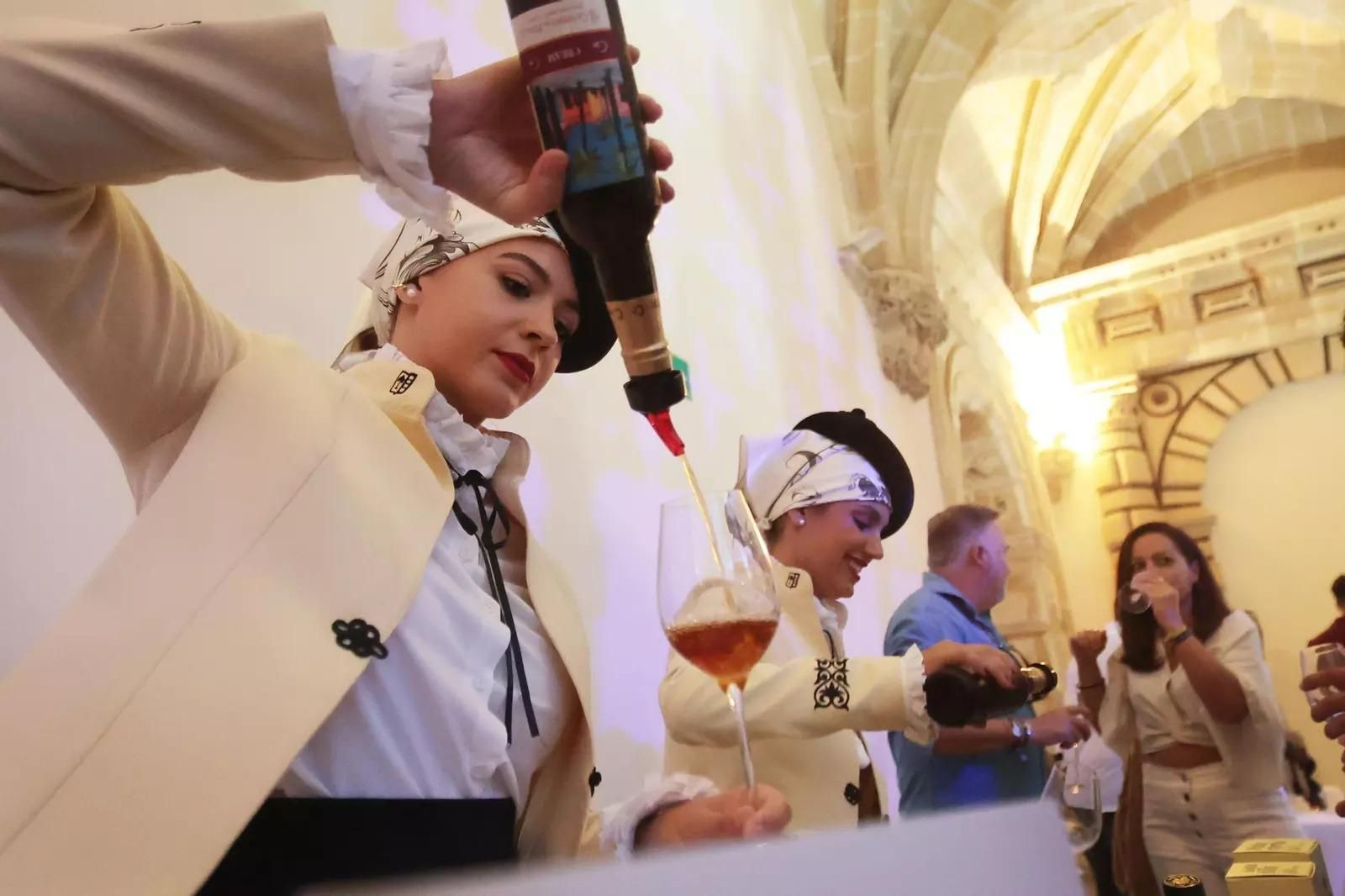 Azafatas de una bodega sirven unas copas de jerez en una muestra de vinos.