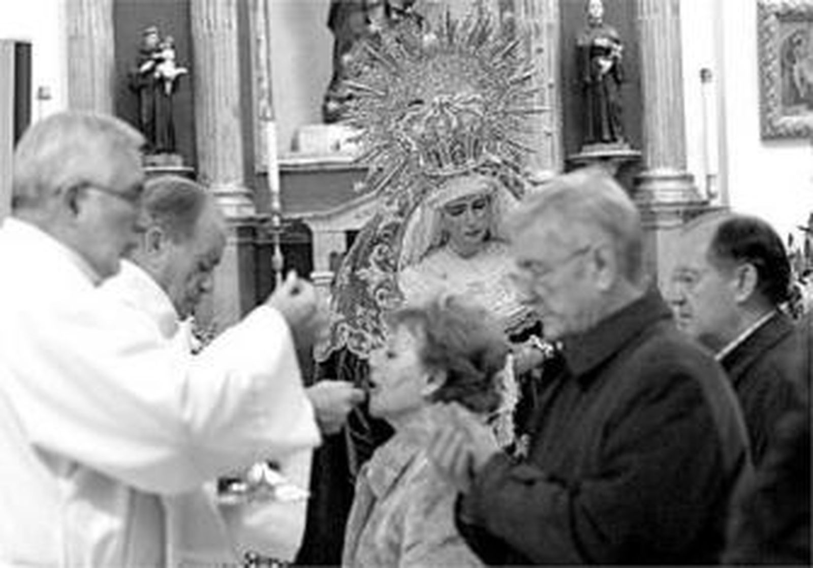 Los fieles reciben la comunión, ante la imagen de la Amargura.