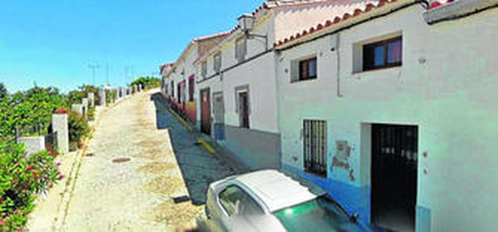 En primer término, con un coche en la puerta, la vivienda en la que se produjo el suceso el pasado domingo.