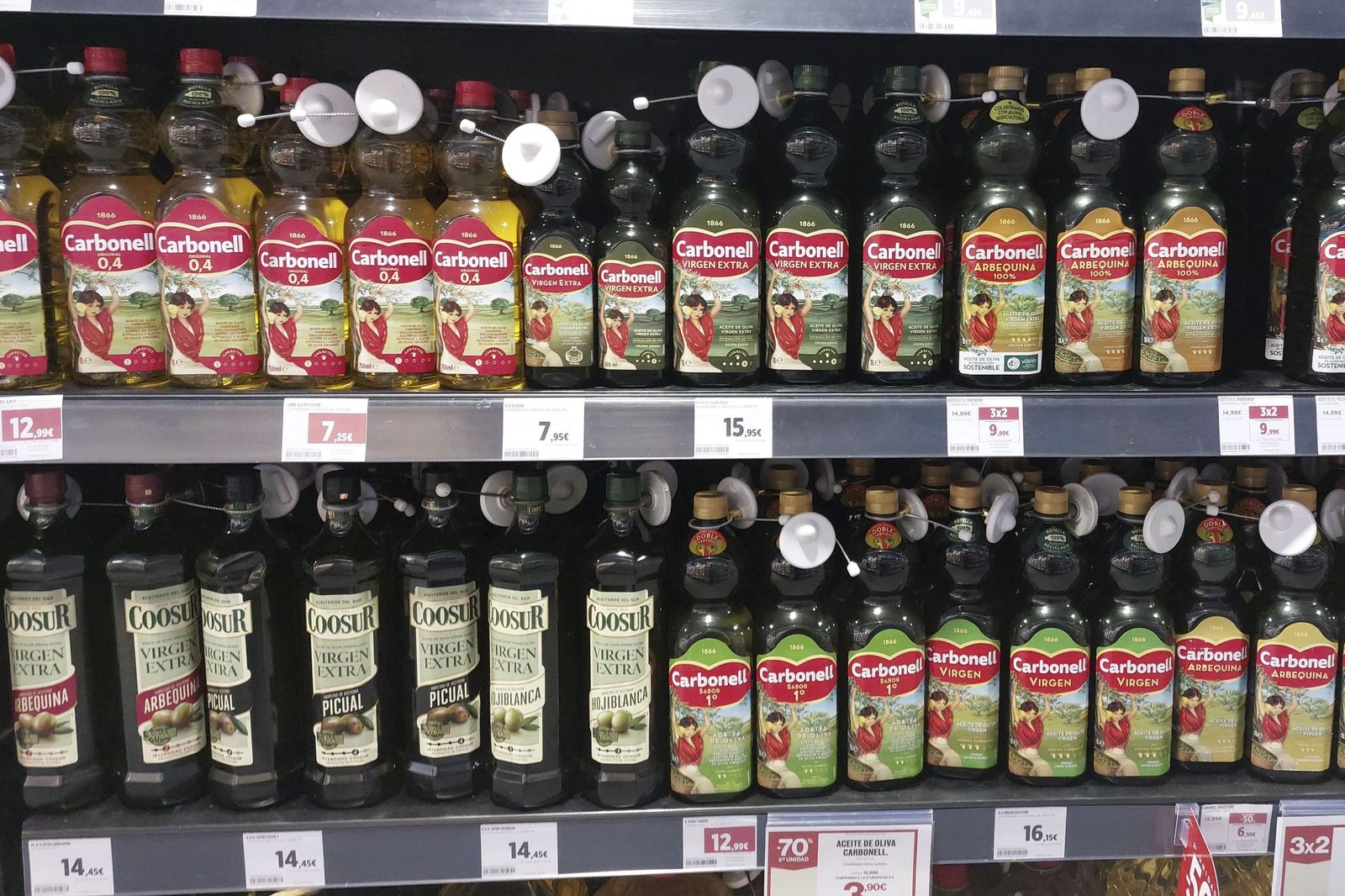 Botellas de aceite de oliva en el lineal de un supermercado.