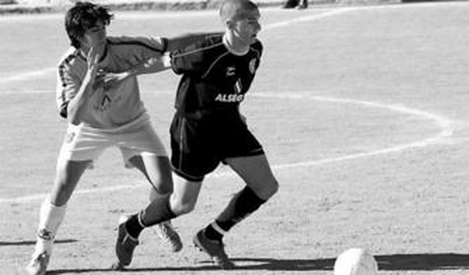 Un jugador del Puerto Malagueño protege el balón ante un rival del Poli Ejido.