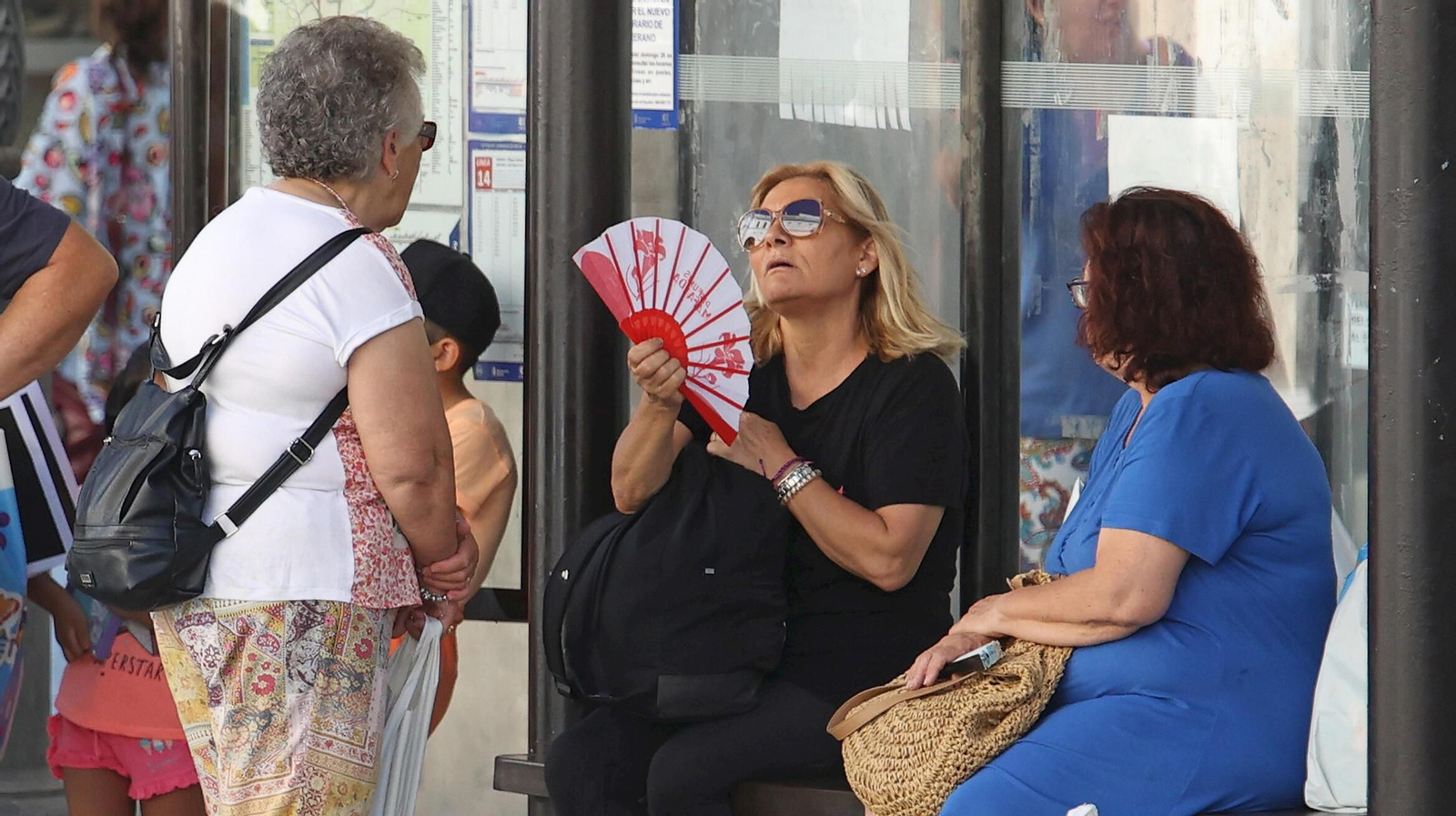 Una mujer se abanica en una parada de autobús en Jerez