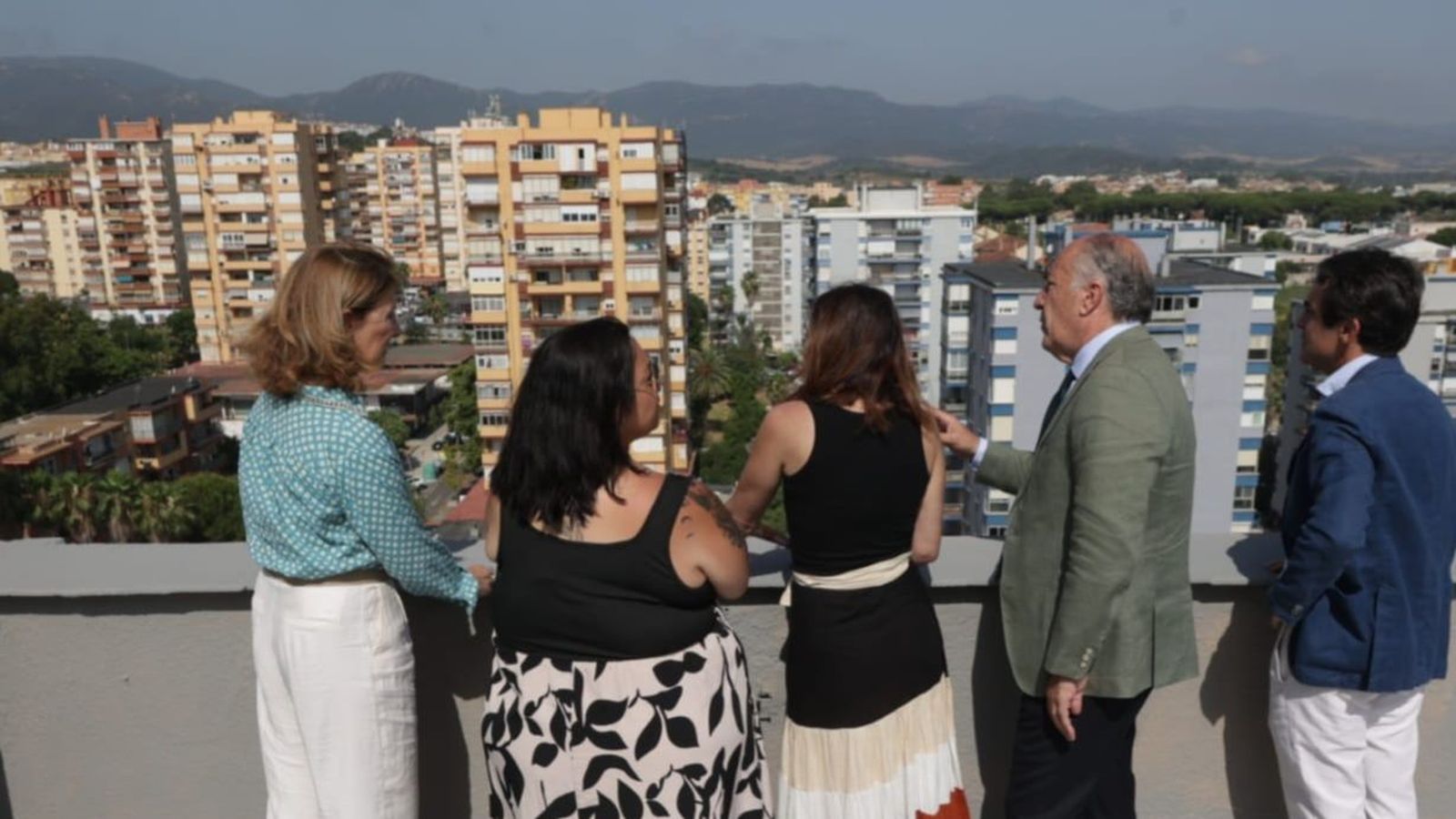 La consejera y las autoridades municipales observan San José Artesano desde lo alto de un bloque.