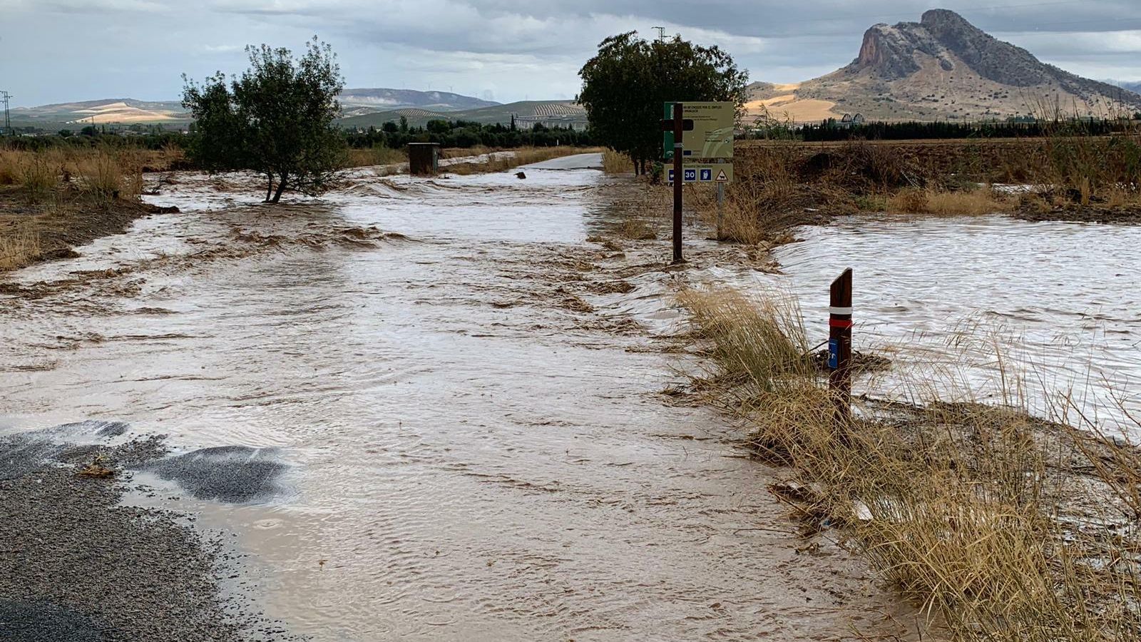 Un arroyo de la Vega de Antequera desbordado, con la Peña de los Enamorados al fondo.