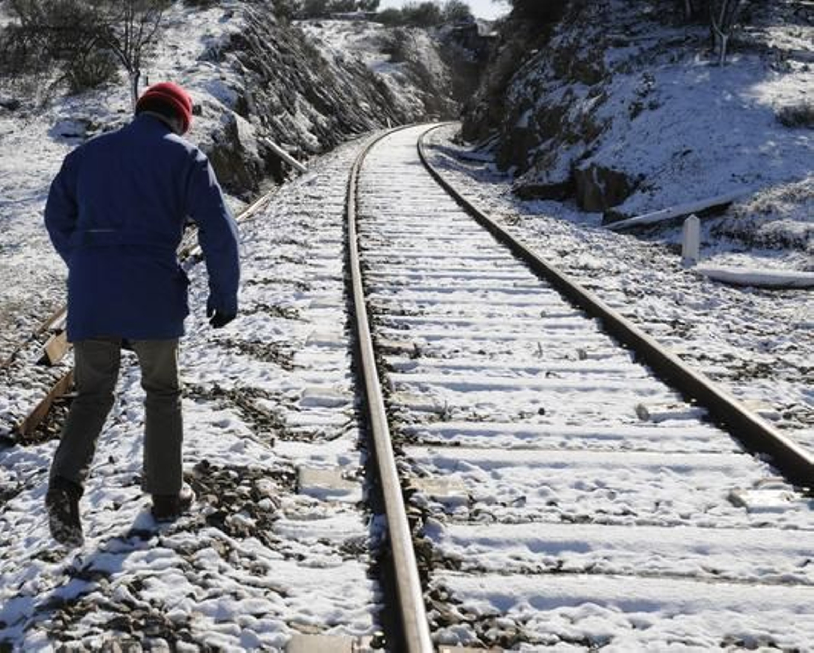 Un hombre camina junto a la vía del tren en el municipio de Guadalcanal, totalmente nevada.

Foto: B.Vargas/Juan Carlos Vázquez