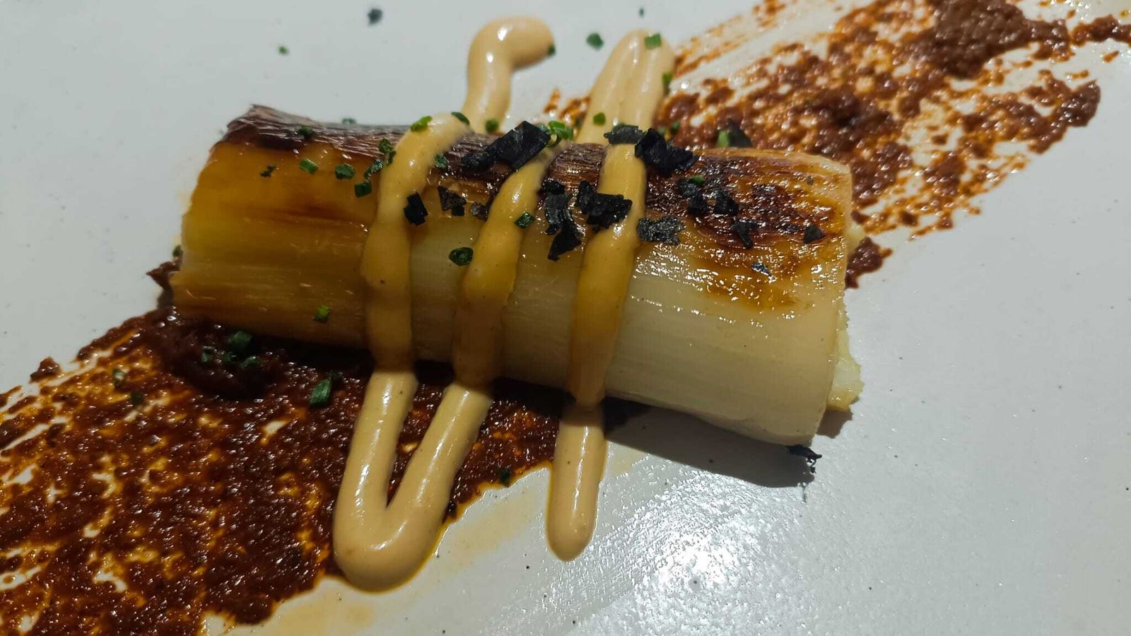 El delicioso puerro a baja temperatura con crema de tomate seco y pipas de calabaza.