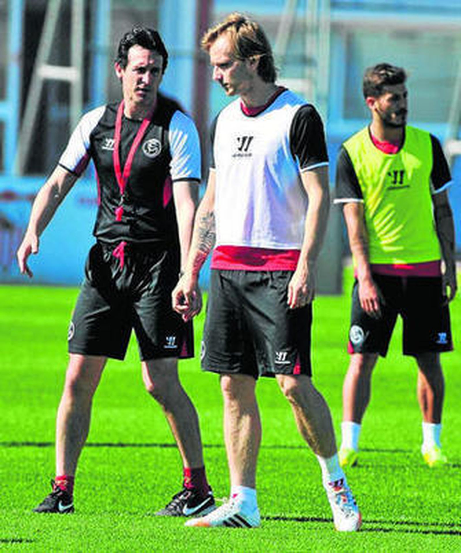 Unai Emery charla con Rakitic en la sesión de ayer.