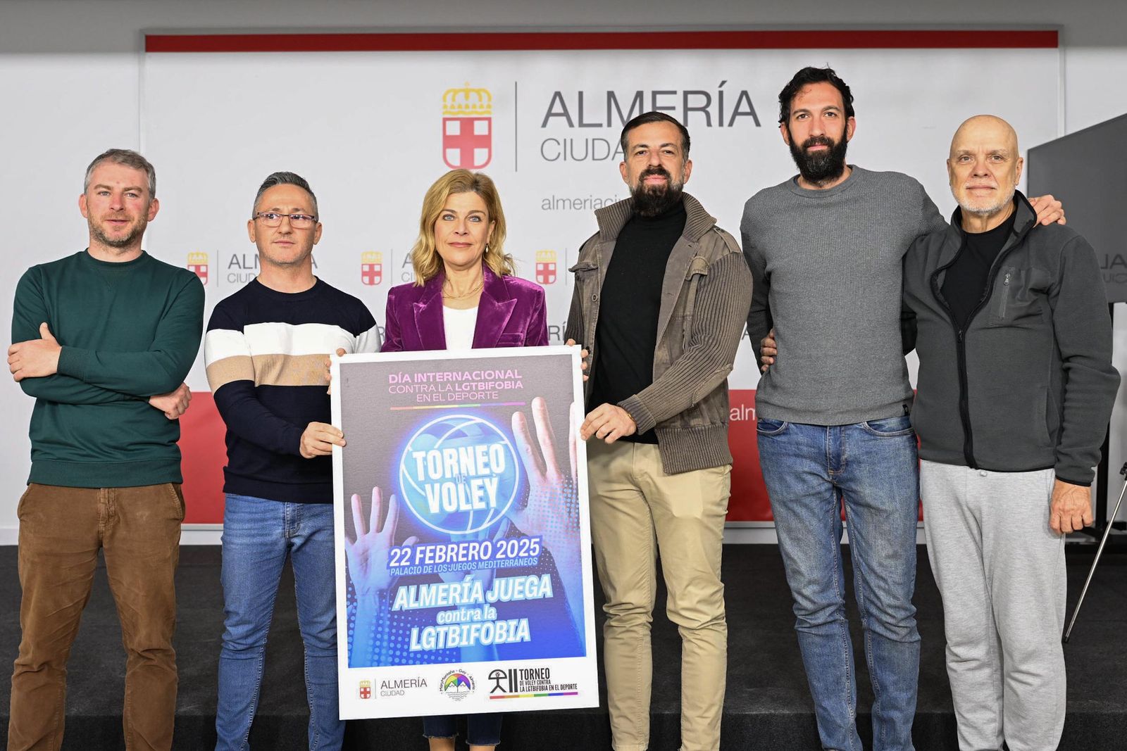 Foto de familia con el cartel de la competición durante la presentación del torneo de voleibol.
