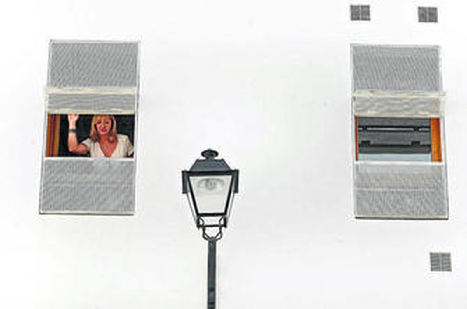 Una inquilina se asoma a la ventana de su piso tras recoger las llaves.