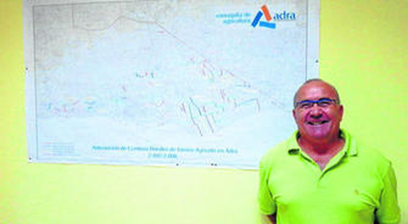 El concejal de agricultura de Adra con un mapa de las zonas rurales del municipio al fondo.