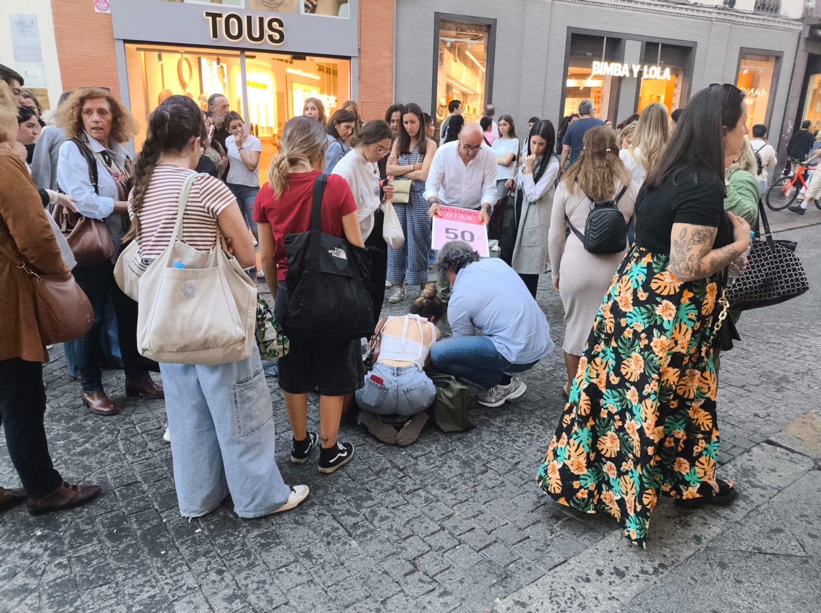 Los peatones auxilian a la mujer que ha sufrido una caída por la cera.