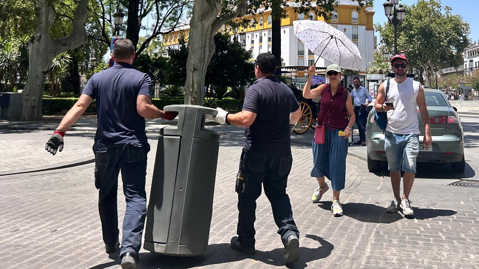 Unos operarios alejan una papelera de la entrada del hotel Alfonso XIII.