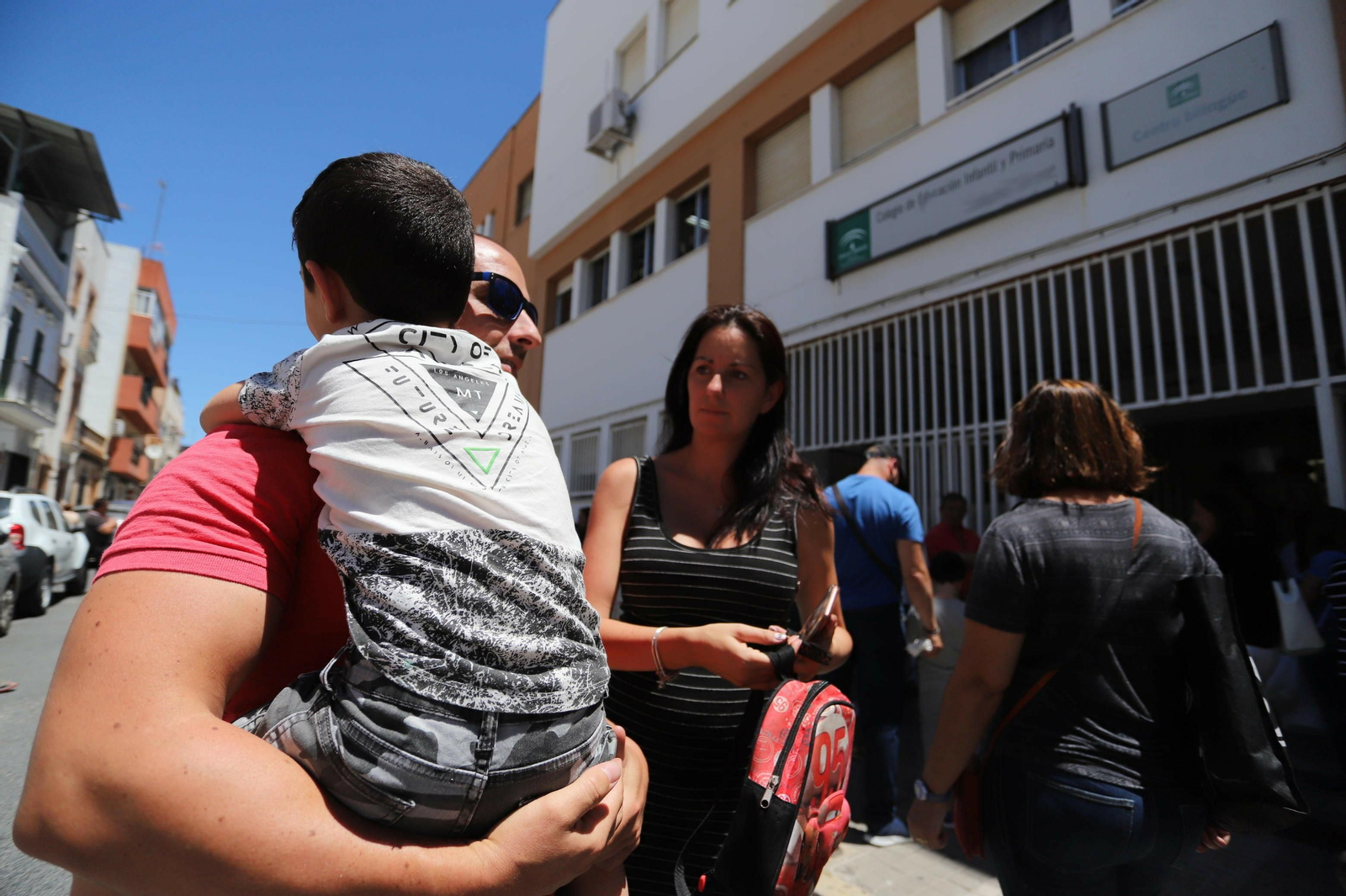 Antonio, con su hijo en brazos, y Rocío a la salida del centro educativo.