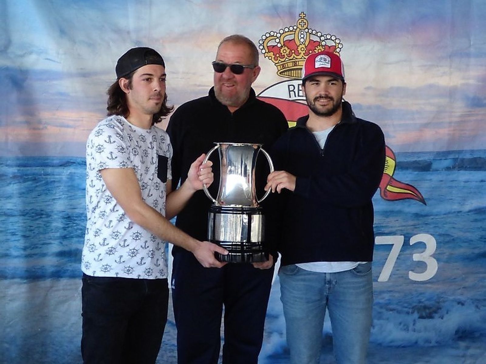 Los vencedores de la regata recogen la copa de campeones.