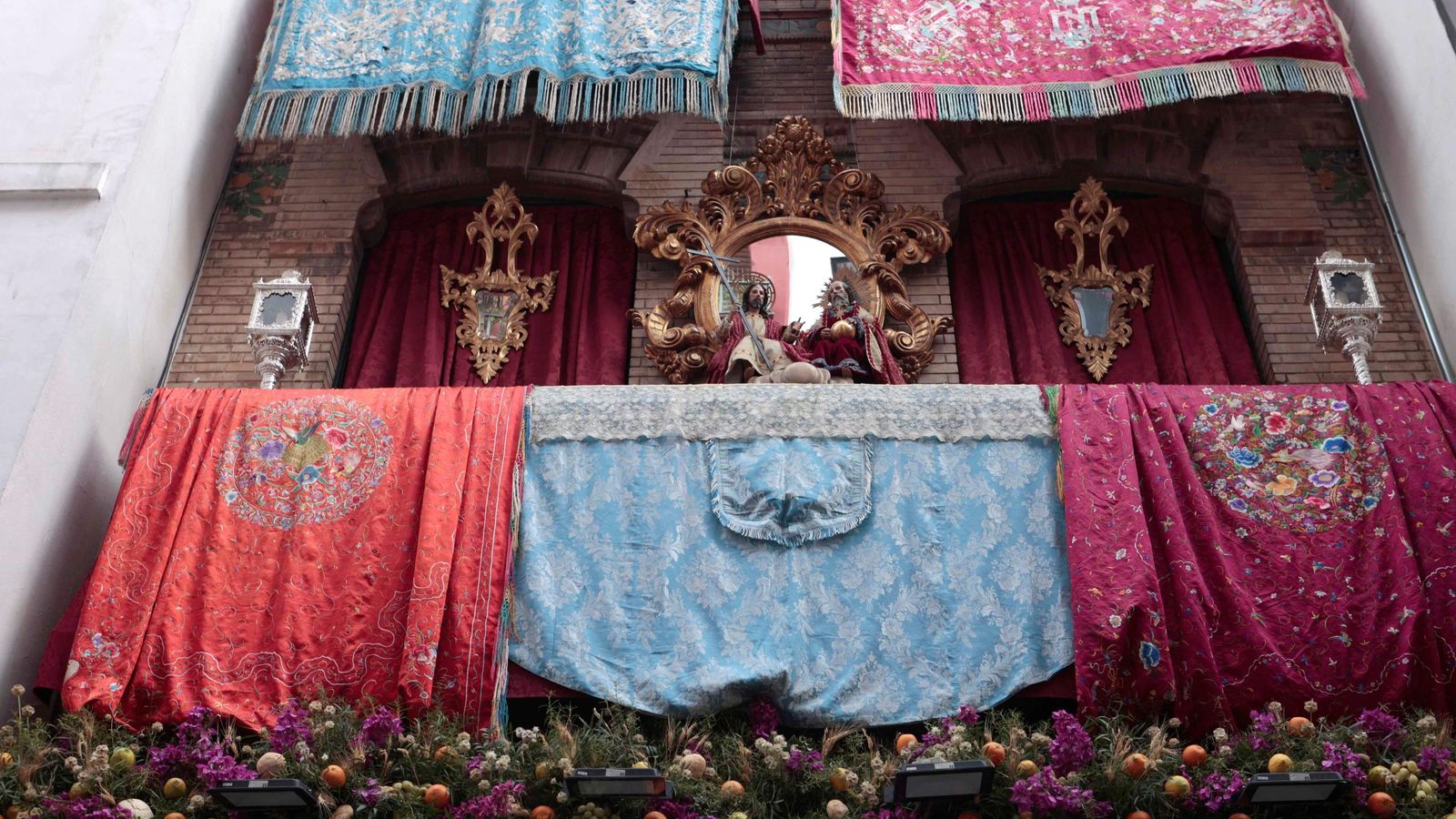 El balcón montado por el Cristo de Burgos, con su colección de colchas bordadas en sedas.