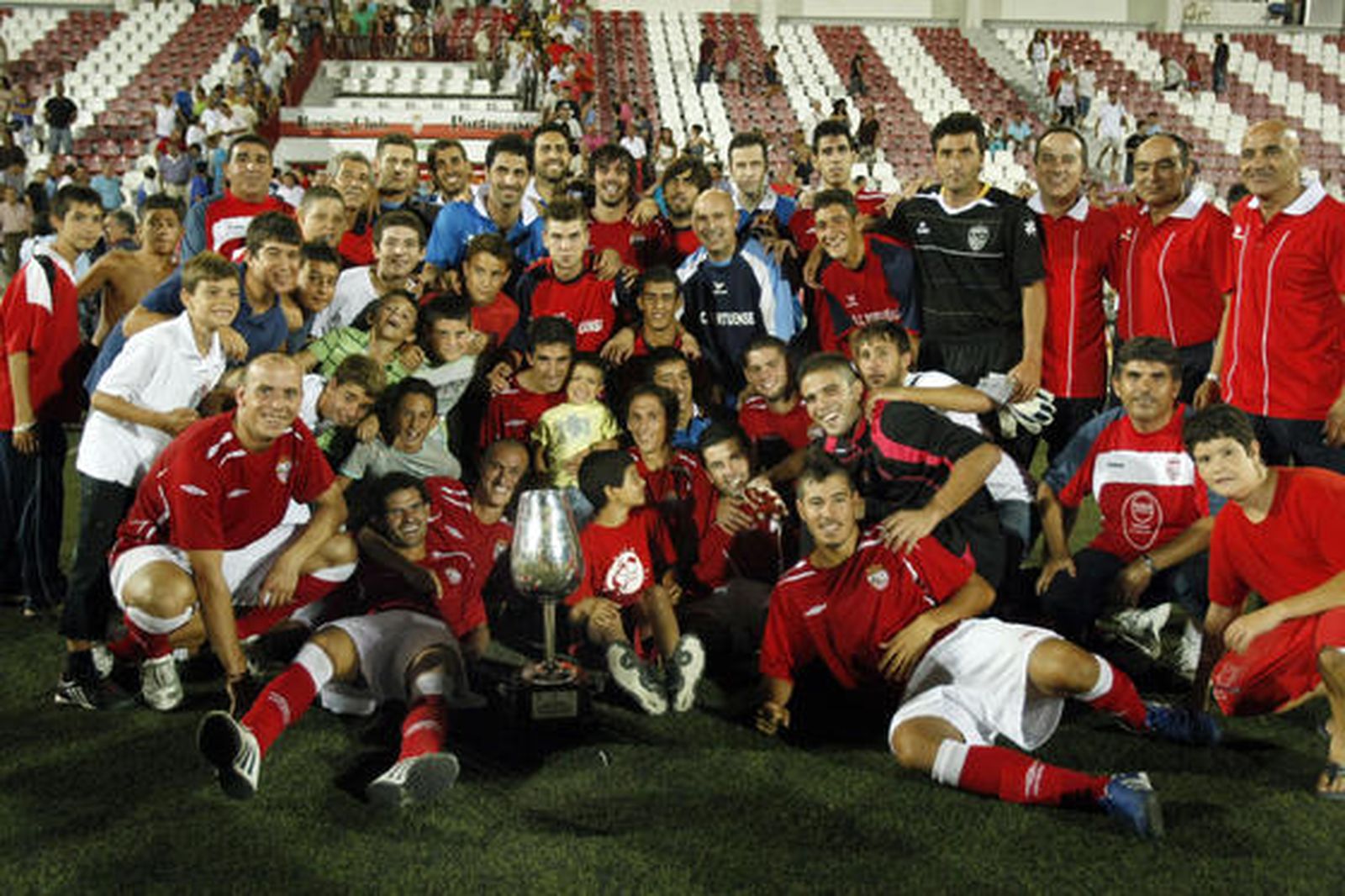 Los jugadores del Portuense posan con el Catavinos. 

Foto: Fito Carreto