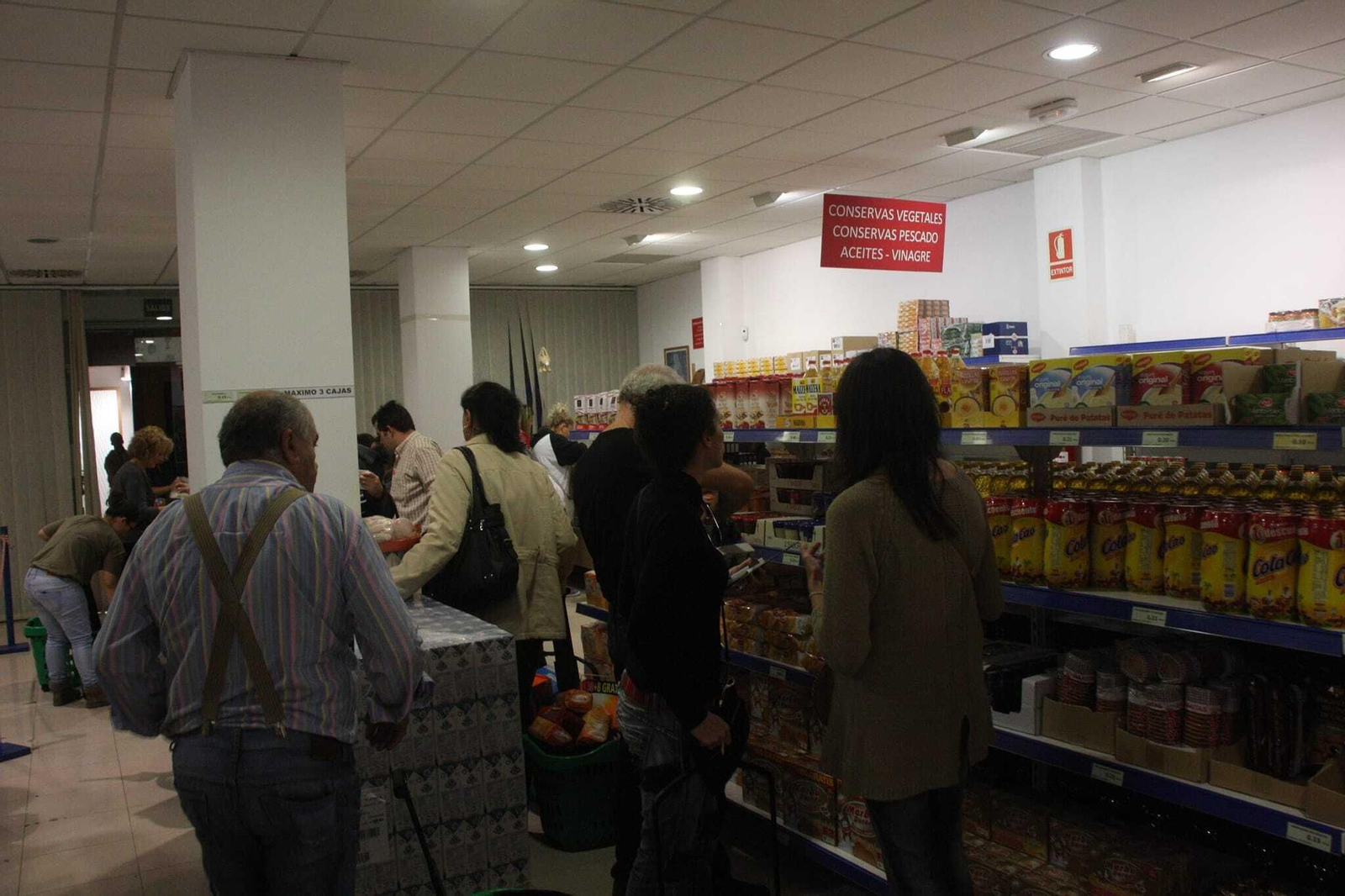 Onubenses haciendo la compra en el economato de Resurgir.