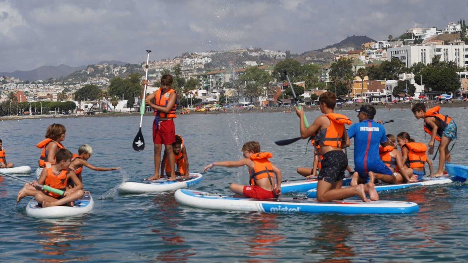 Alumnos del campamento de verano practicando paddle surf
