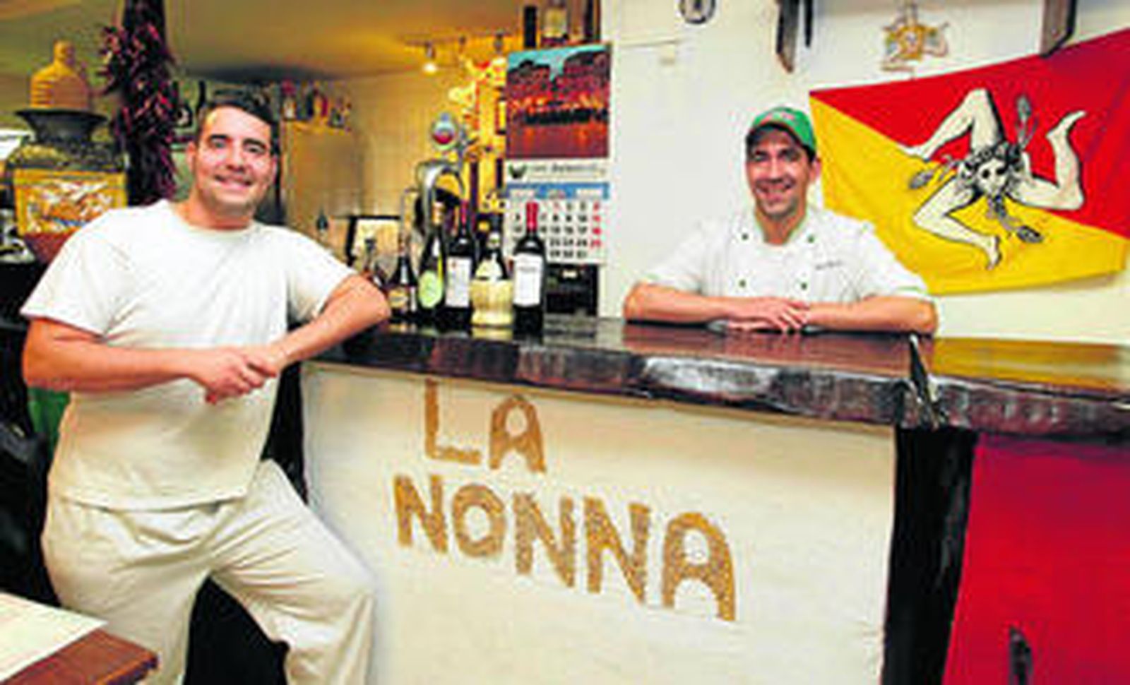 La familia Paravizzinni posa en la barra del local de La Nonna, en el barrio de la Plaza de Toros.