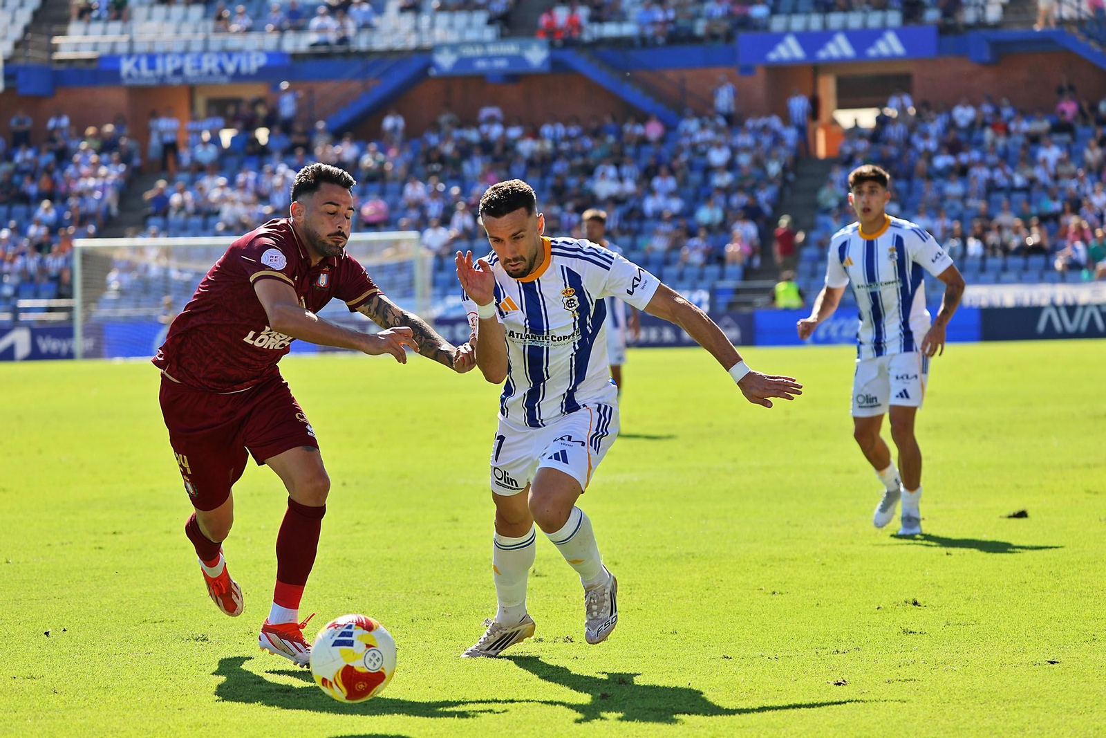 Pugna por un balón entre Alberto López y Acevedo en el Recre-Lorca.
