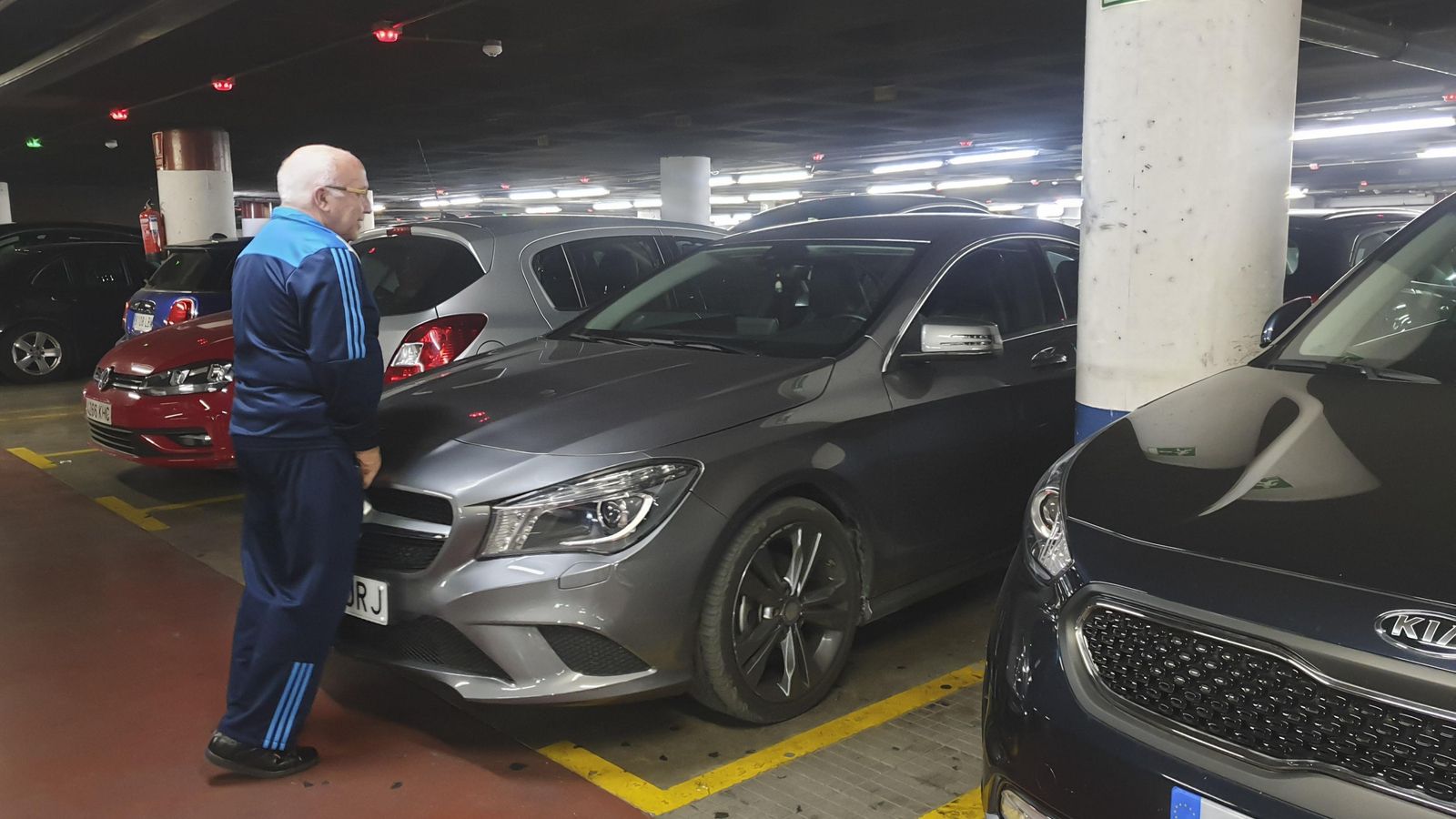 Un hombre empuja su coche para estacionarlo en La Marina.