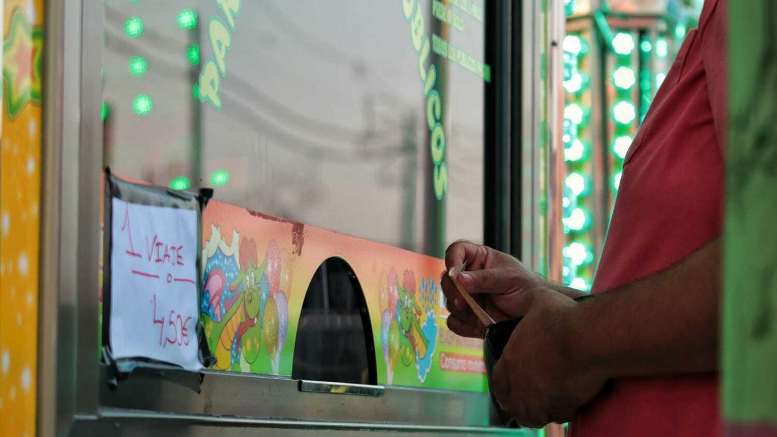 Persona pagando una atracción en la Feria.