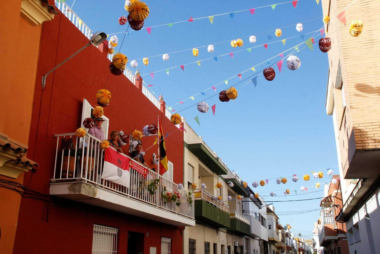 Vecinos de la calle Revolera, rodeados de farolillos en la semana de la Feria portuense.