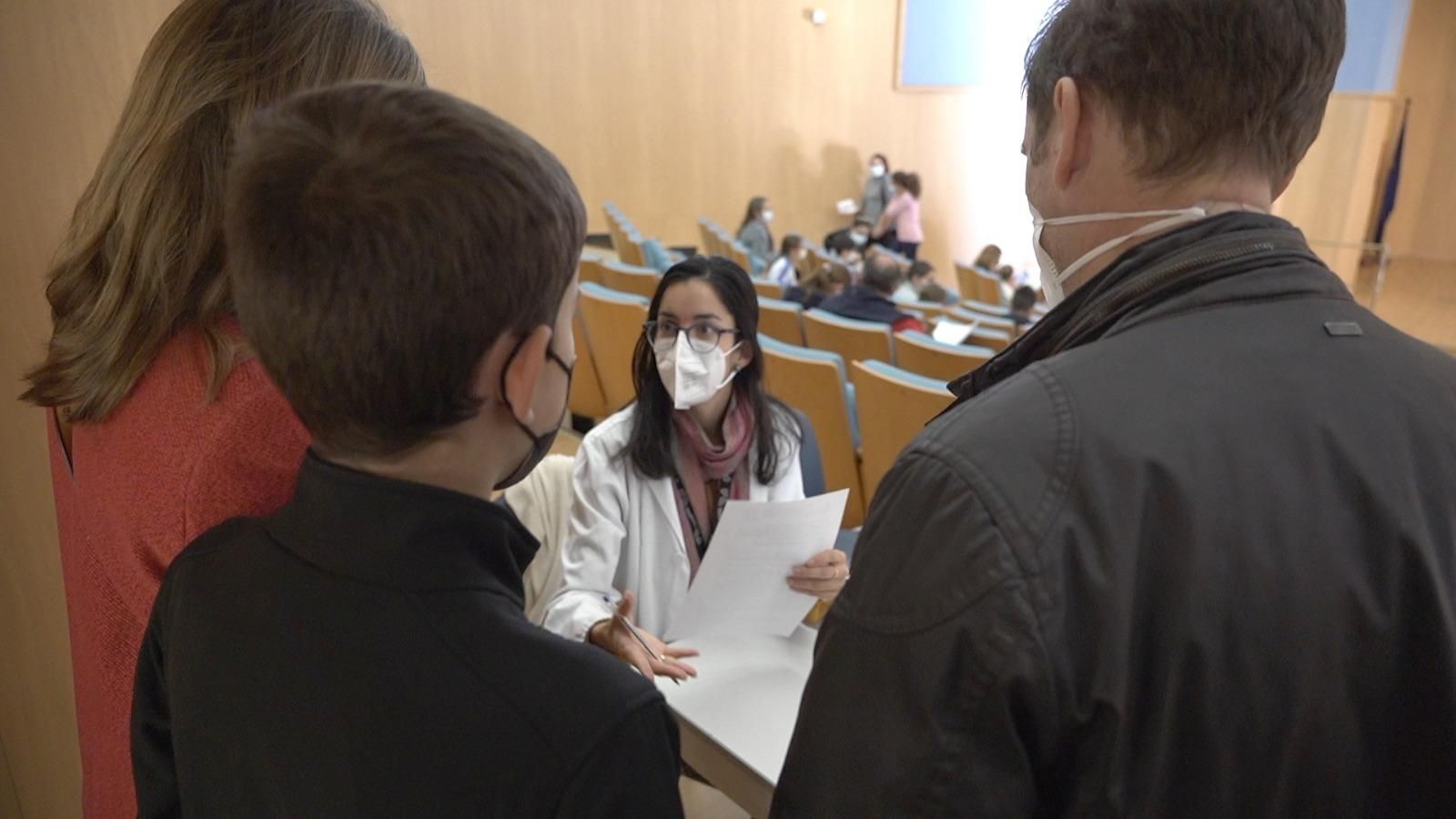 Una familia es atendida por una sanitaria en el registro previo a la vacunación en el Hospital de Valme.
