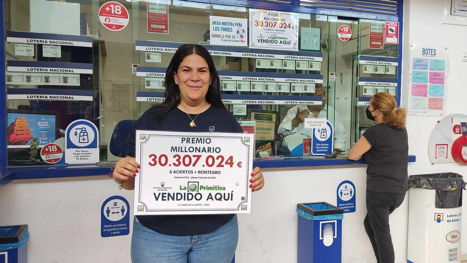 Alicia Montes sostiene el cartel con el primer premio de La Primitiva