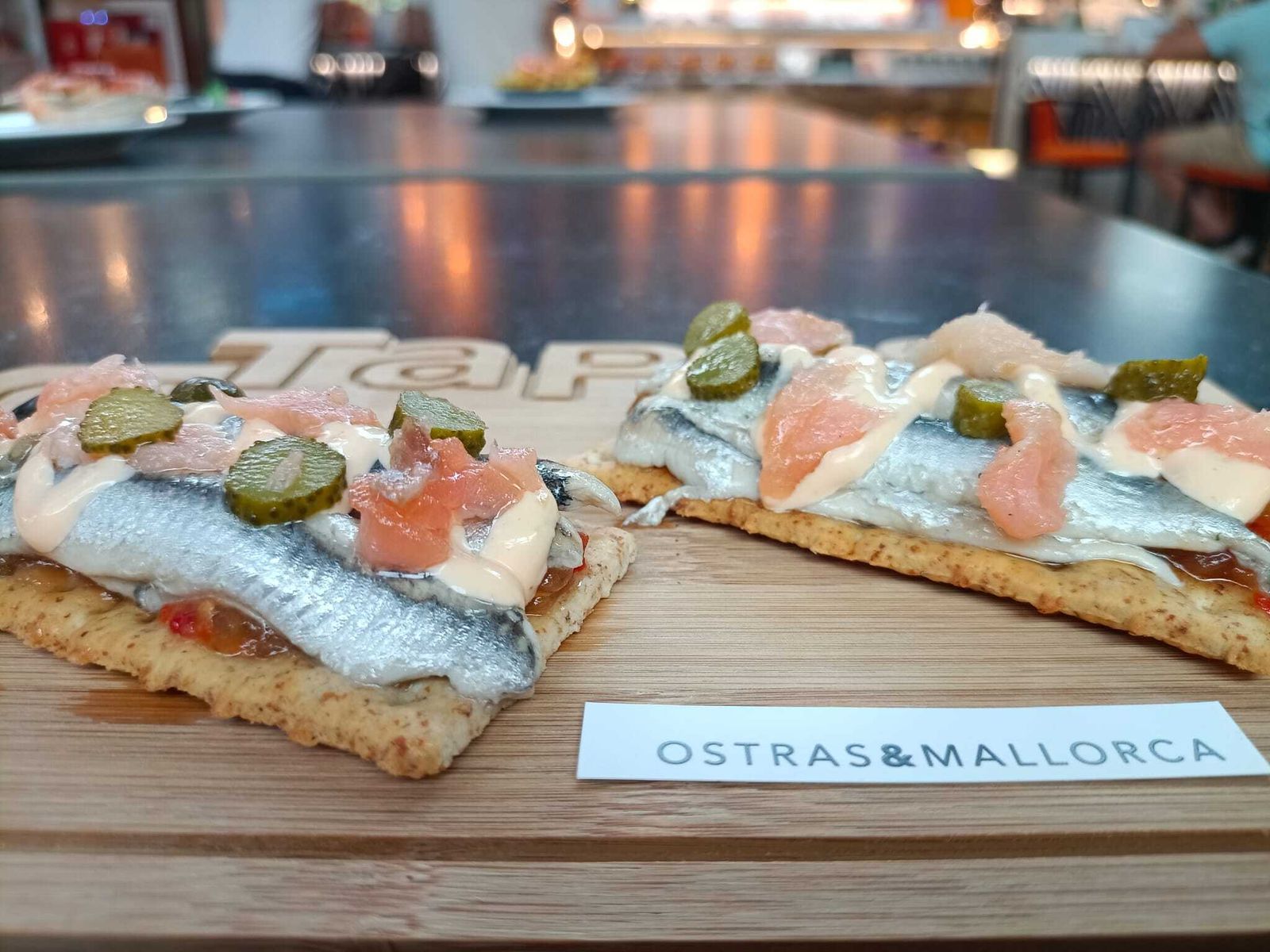 Tostas Valkiria (boquerones en vinagre, cama de Cherrys, cebolla caramelizada, pimiento, salsa kimchi, salmón y penillo) de Ostras & Mallorca