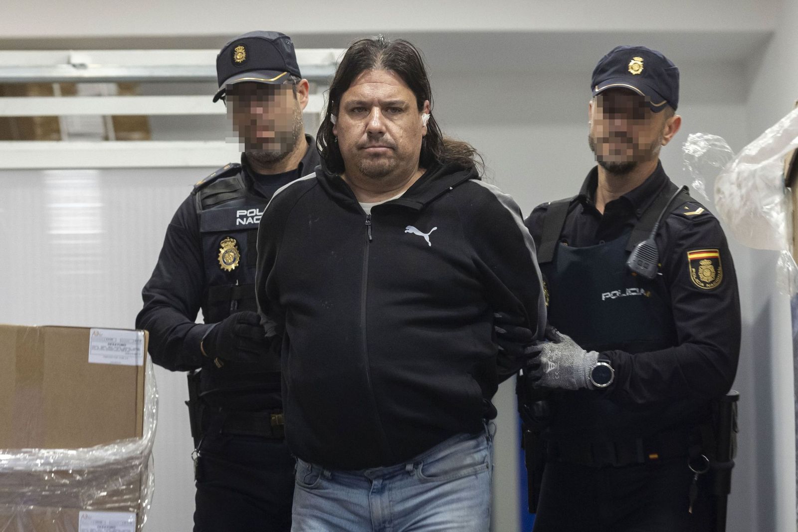 Agentes de la Policía Nacional trasladan al presunto secuestrador de una mujer en Murcia.