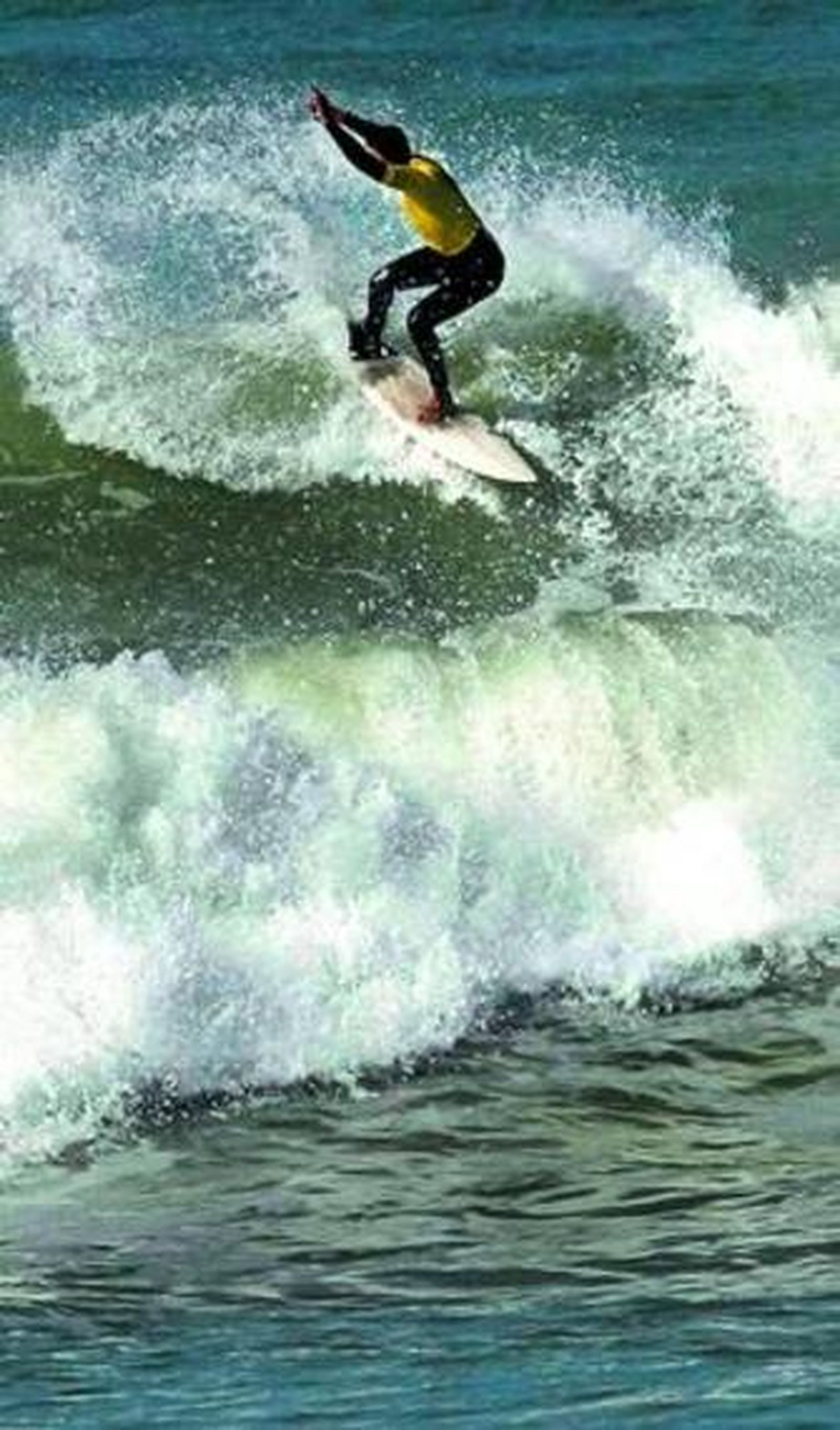 Un surfista se enfrenta a una ola en la playa de Cortadura de Cádiz.
