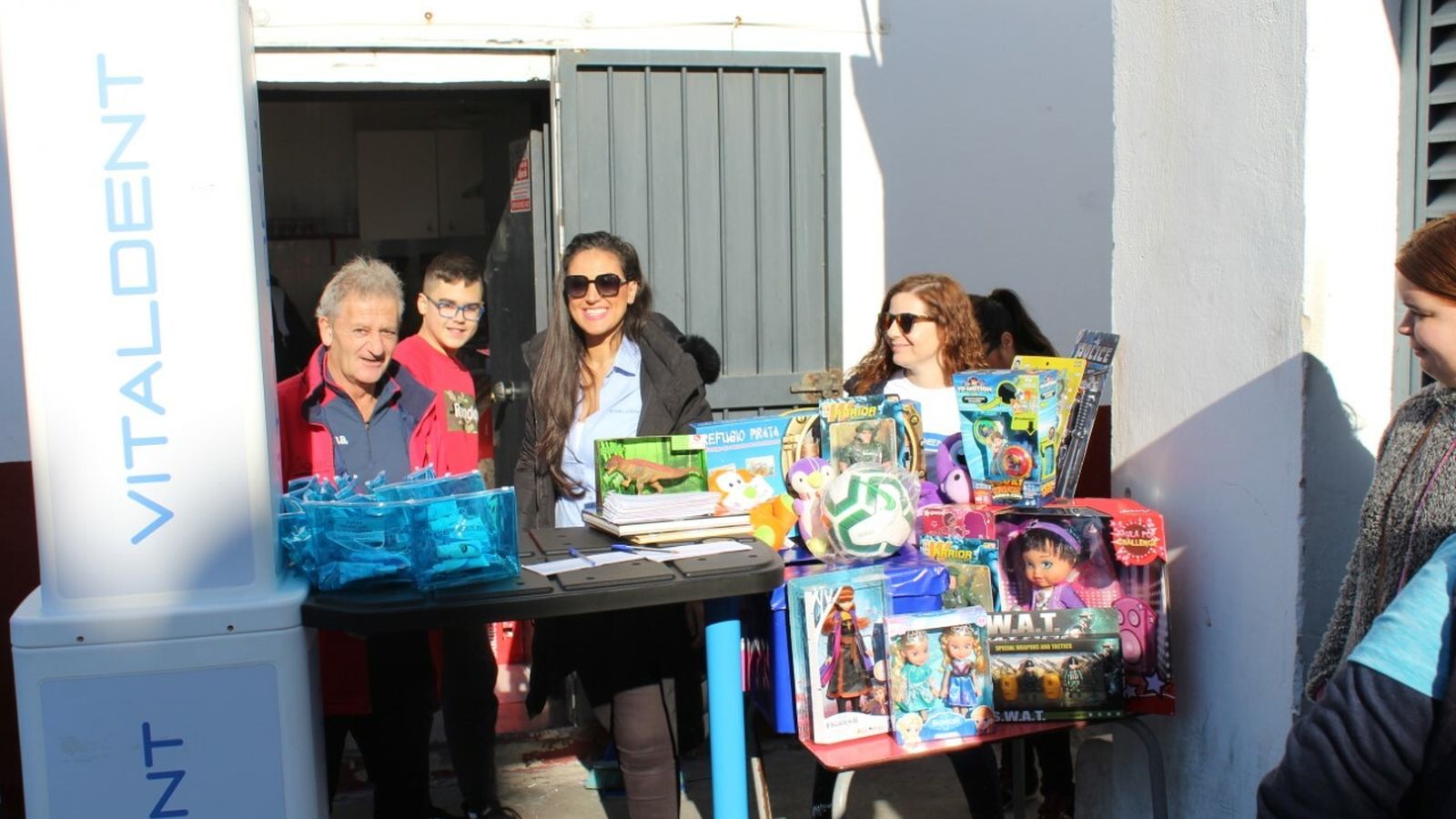Voluntarios recogen juguetes antes del partido.
