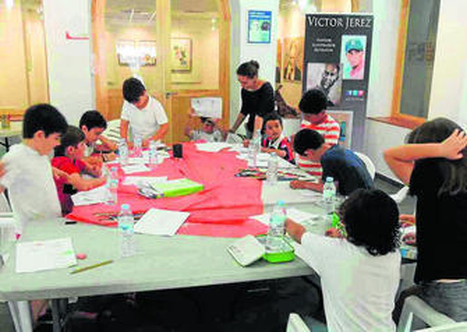 Imagen del grupo de pequeños aprendices junto a la monitora del taller, Cris L. Vargas.