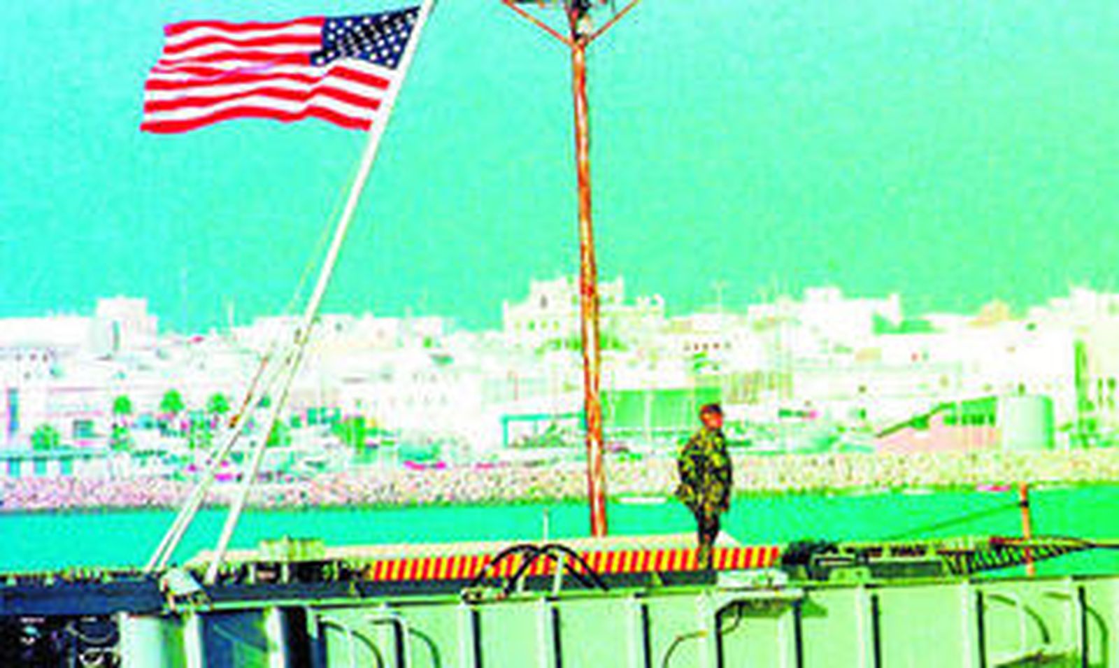 Imagen de archivo de un militar haciendo guardia a bordo de un buque estadounidense en el puerto de la Base. Al fondo, una panorámica de Rota.
