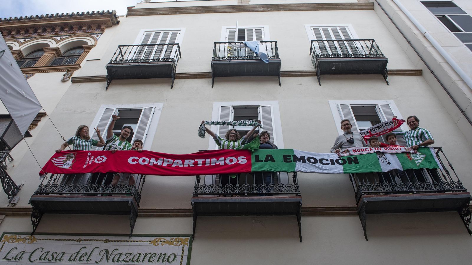 Aficionados posan con una bufanda conmemorativa del derbi realizada por LaLiga.