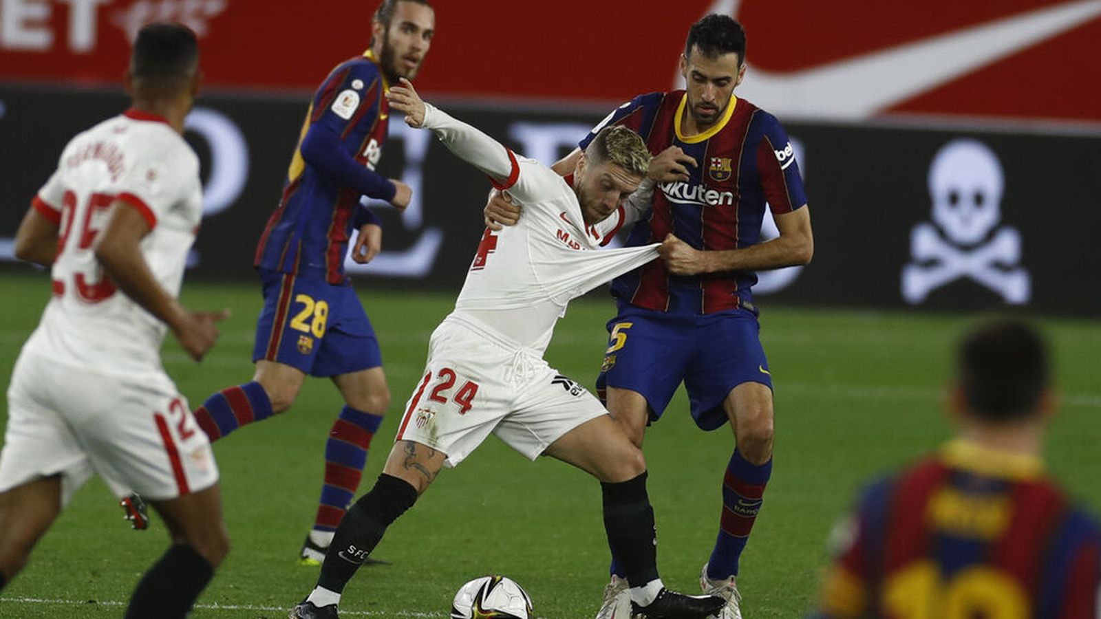 Sergio Busquets agarra de la camiseta al Papu Gómez.