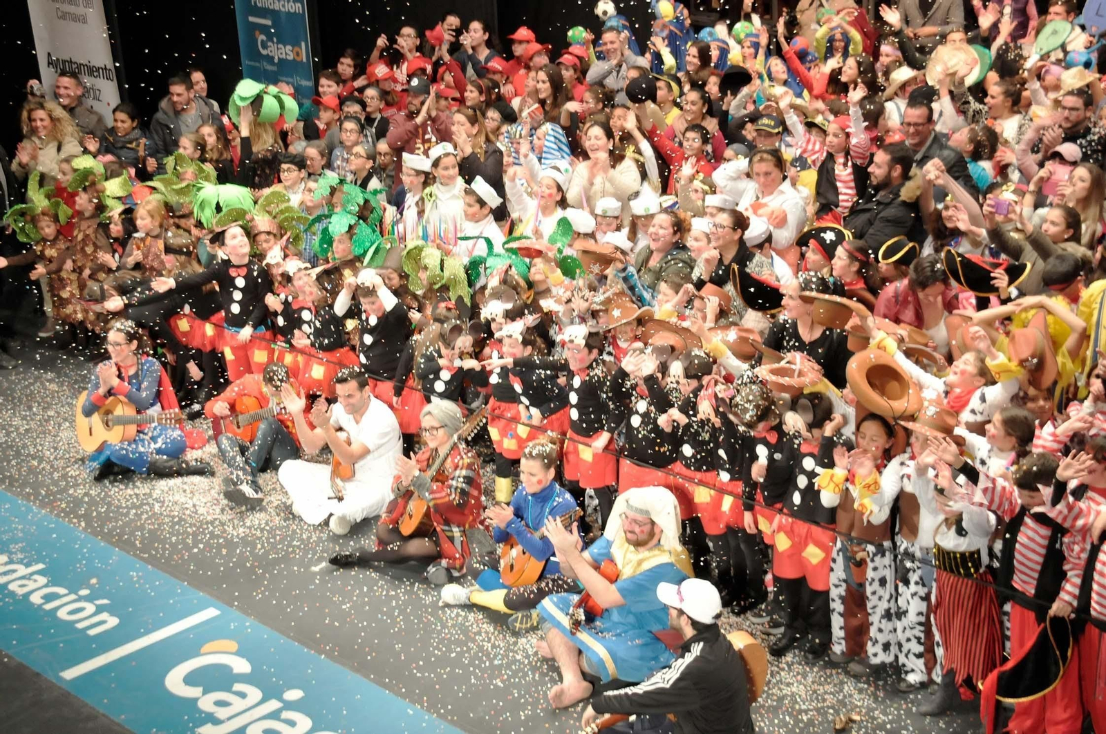 Los integrantes del Carnaval en la Escuela al final de la gala del año 2015 saludando en el escenario del Falla.