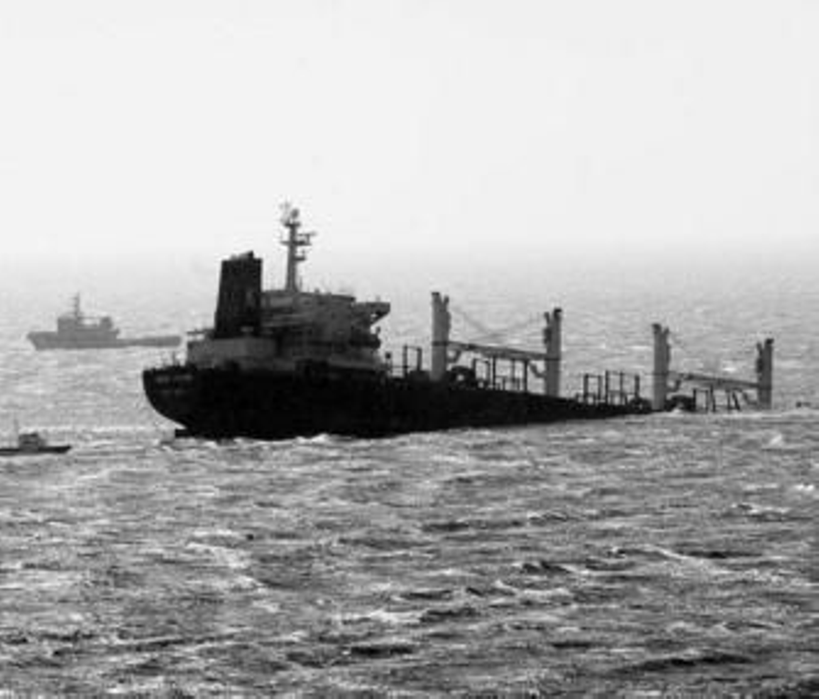 El 'New Flame', horas después del accidente, el 12 de agosto, y al fondo un buque de Salvamento Marítimo.