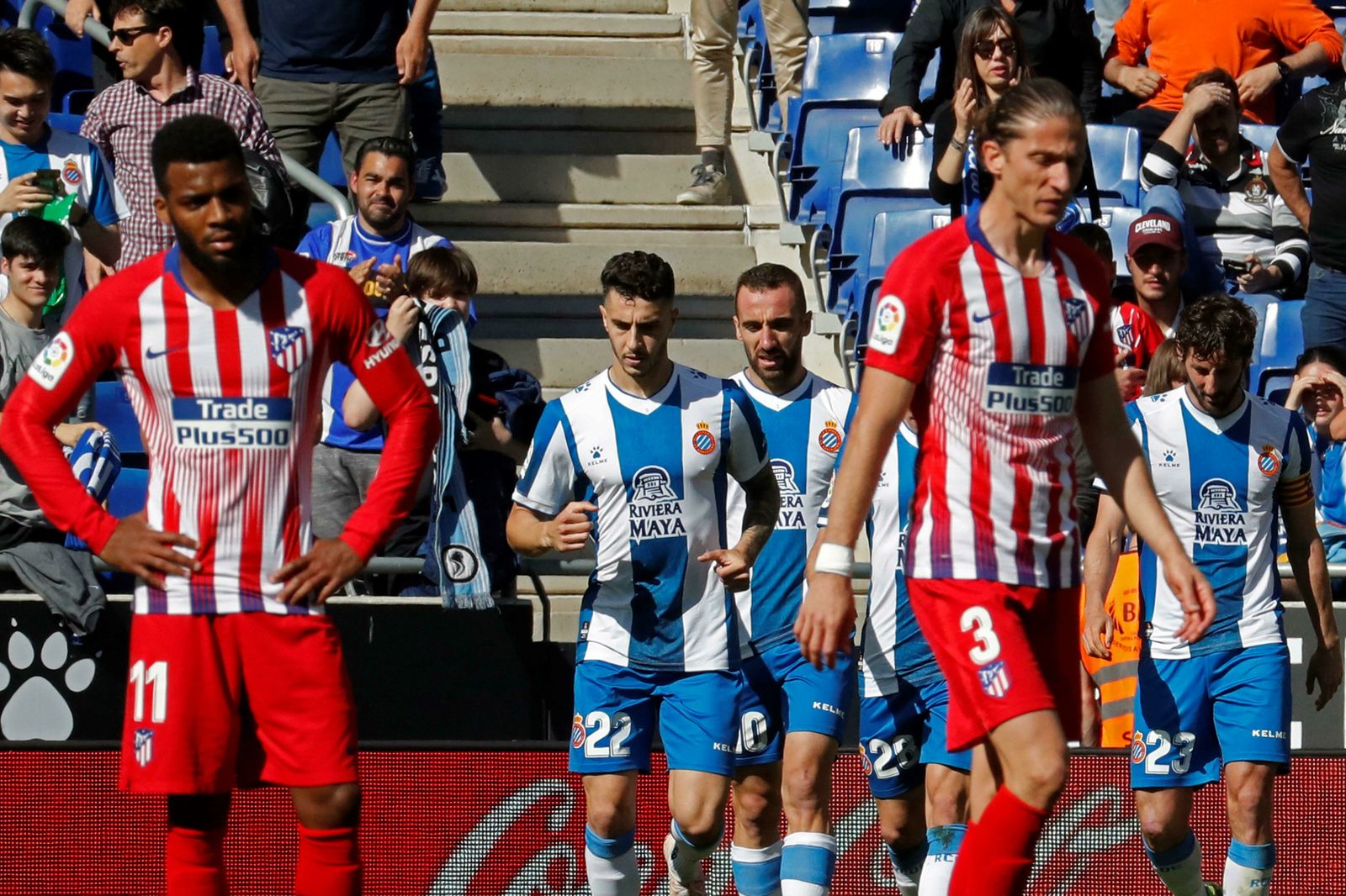 Los jugadores del Espanyol celebran uno de los tantos ante los desolados Lemar y Filipe Luis.