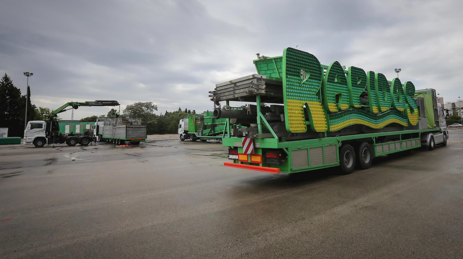 La explanada de la Feria este domingo con varios camiones transportando las atracciones.