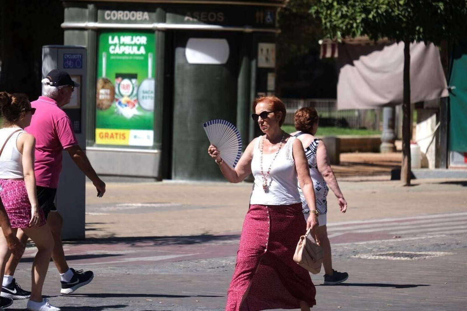 Una mujer se abanica en una calle de Córdoba.
